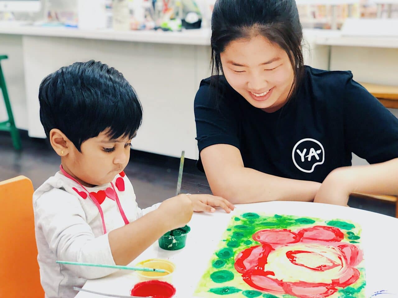 young art student with teacher making art