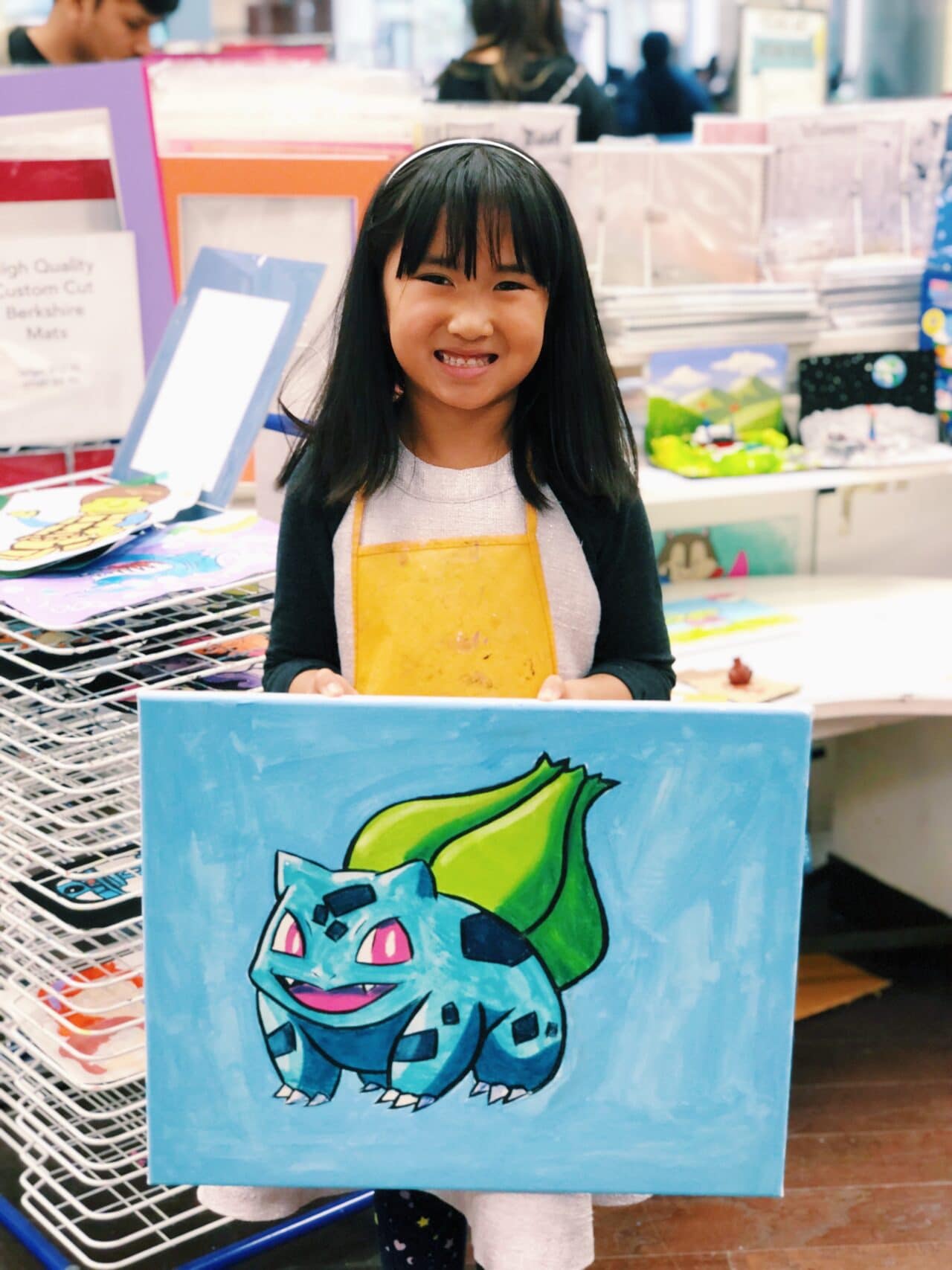 image of student holding artwork of pokemon