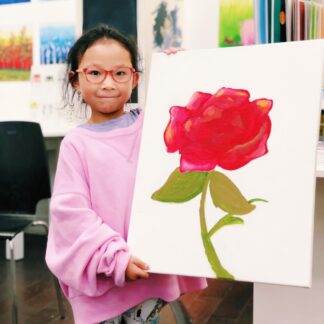 image of student holding painting of rose