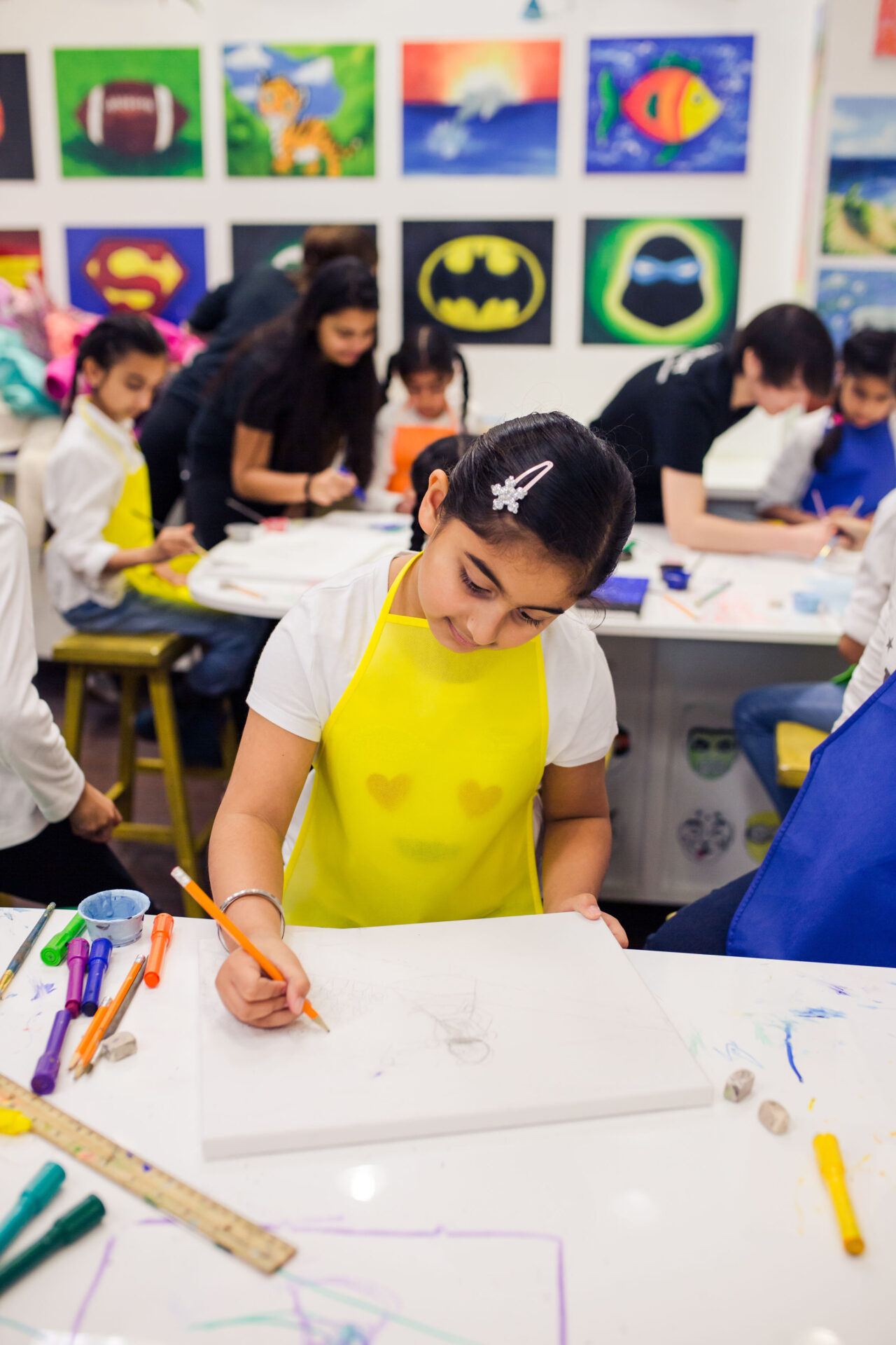 art student with yellow apron doing artwork at Young Art