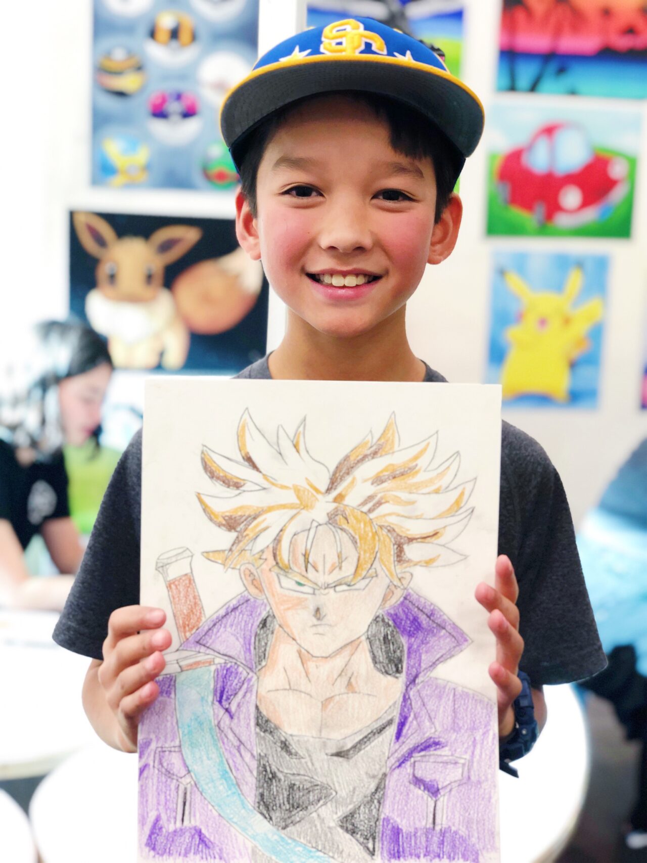 image of student holding artwork of anime sketch