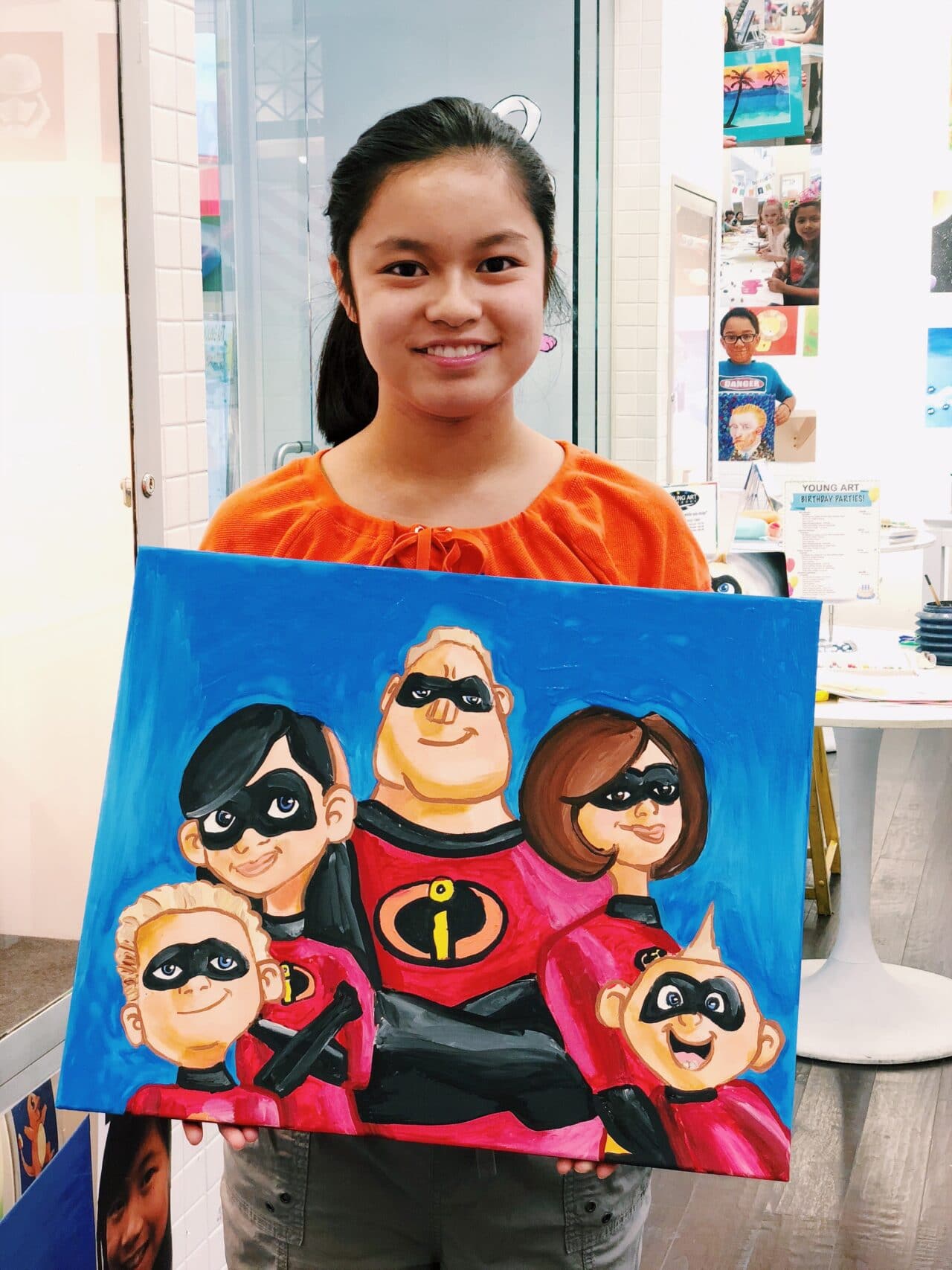 image of student holding painting of the incredibles