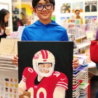 student holding art football player