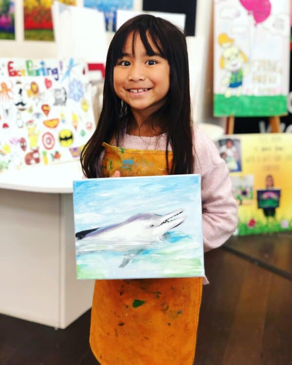 student showing art dolphin