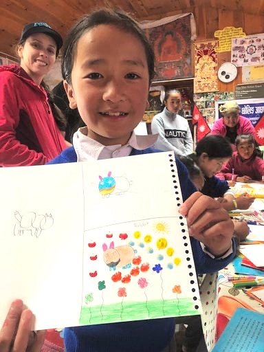 image of a young boy holding his drawing up
