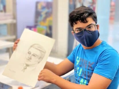 boy holding sketch of a face