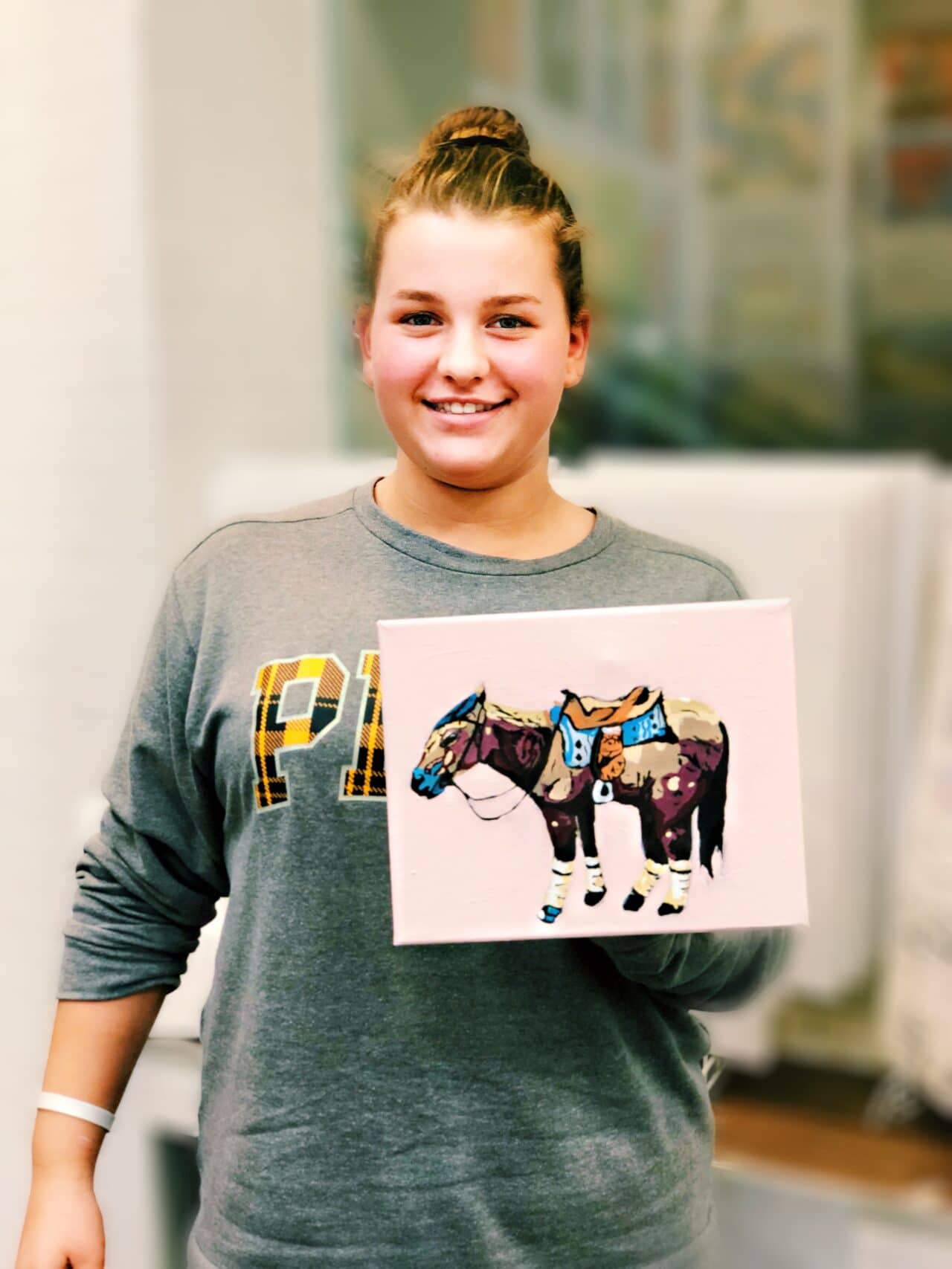 girl holding painting of a horse