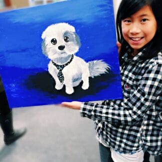 a girl showing her painting of a puppy