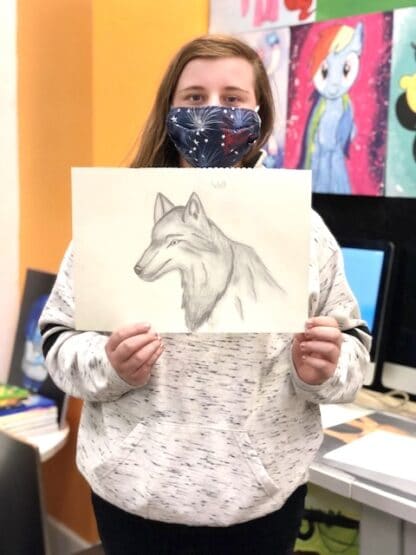 image of girl holding pencil sketch of a wolf head