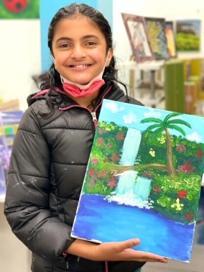 image of a girl holding a canvas painting of a tropical waterfall