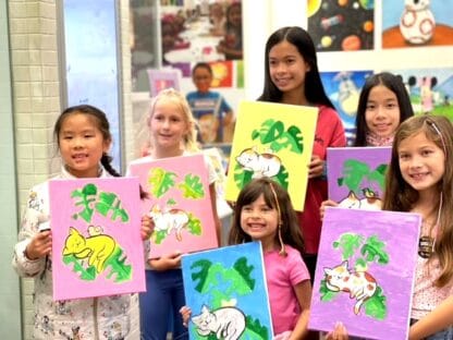 image of a group of girls holding canvas paintings of cats