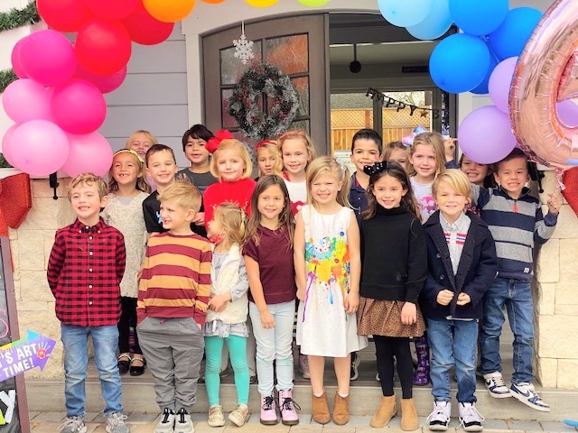 image of birthday guests standing in front of colorful balloon art