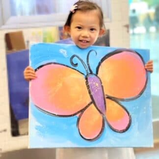 image of a student holding an orange and pink butterfly painting