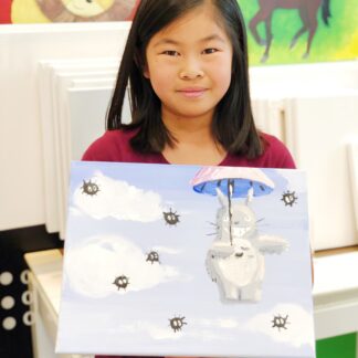 girl holding a canvas painting of Totoro character