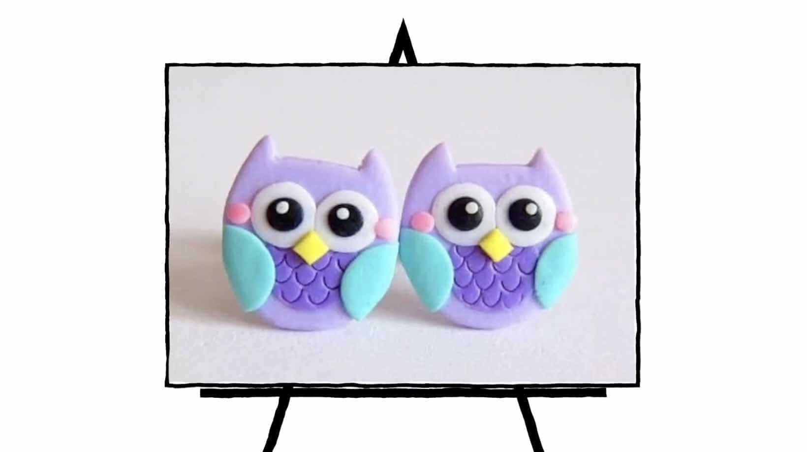 image of two clay owls with purple bodies and teal wings, yellow nose, big eyes
