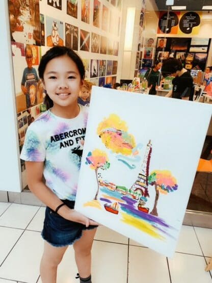 image of student holding artwork