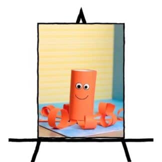 image of orange paper tube with smiling face and rolled paper on sides to look like an octopus