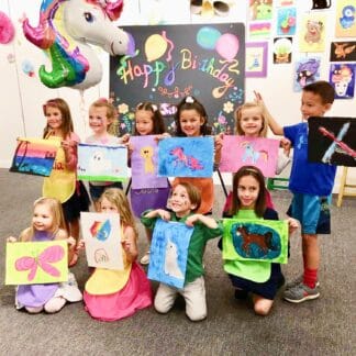 image of birthday party guests holding their artwork