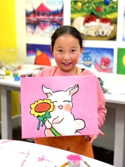 girl holding canvas painting of white bunny with sunflower