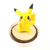 image of a clay figure of pikachu sitting on a wood coaster
