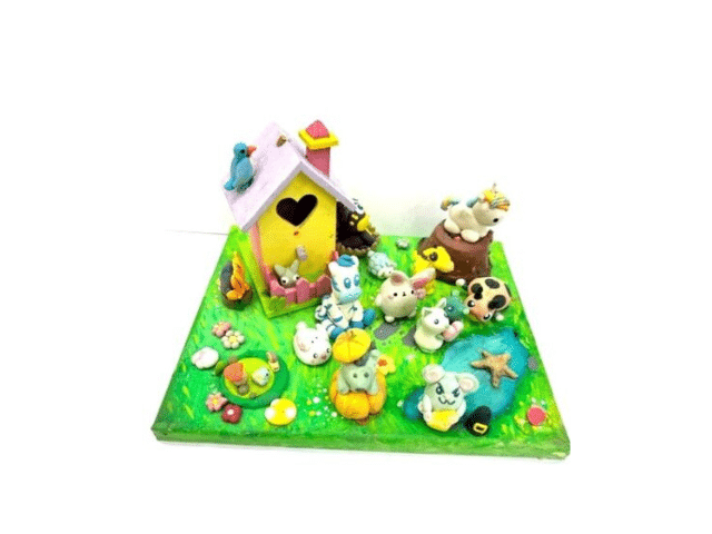 image of a canvas decorated to make a spring scene with clay creatures