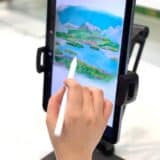 image of a hand drawing on and iPad. scenery of a lake depicted on iPad screen