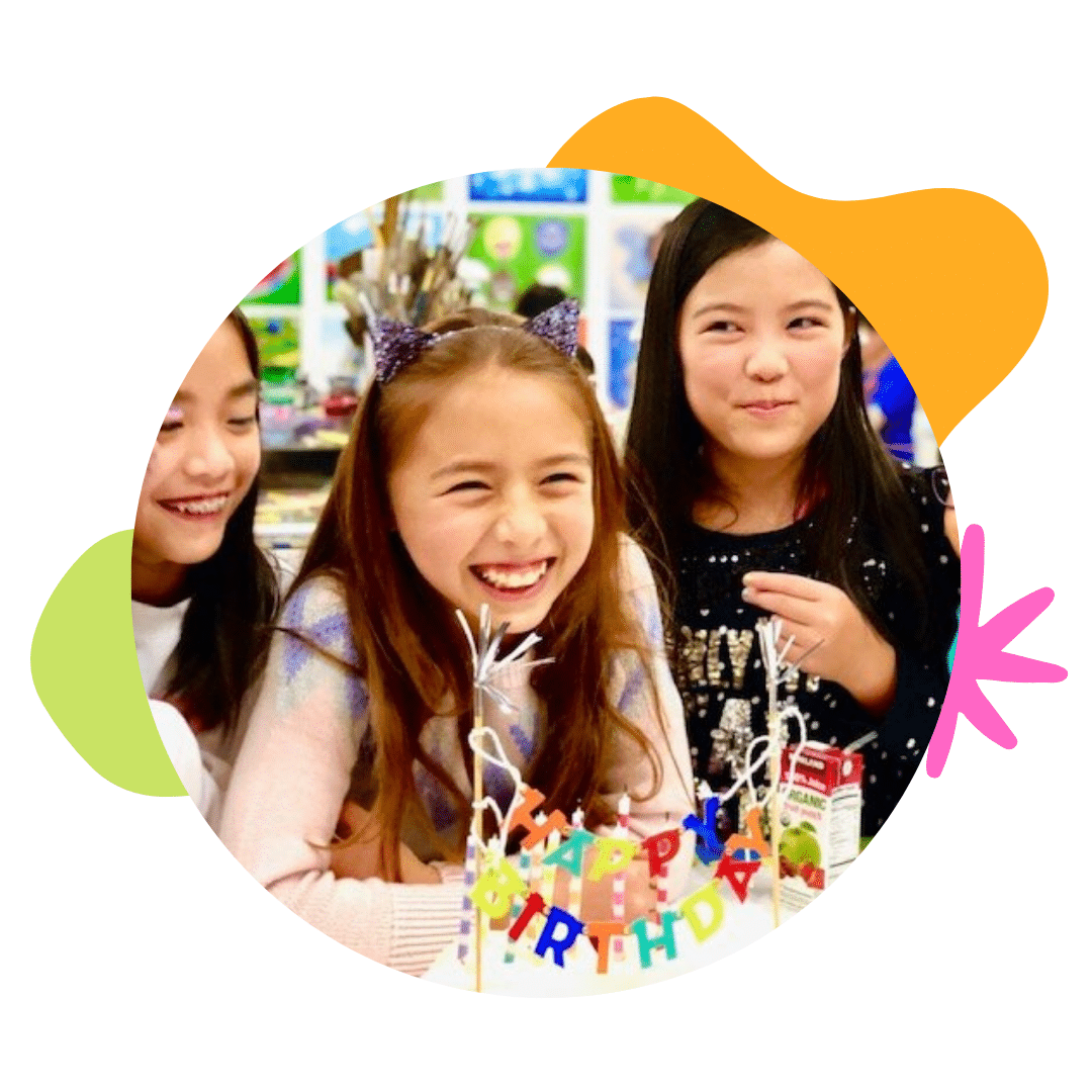 image of three girls smiling in front of a happy birthday sign
